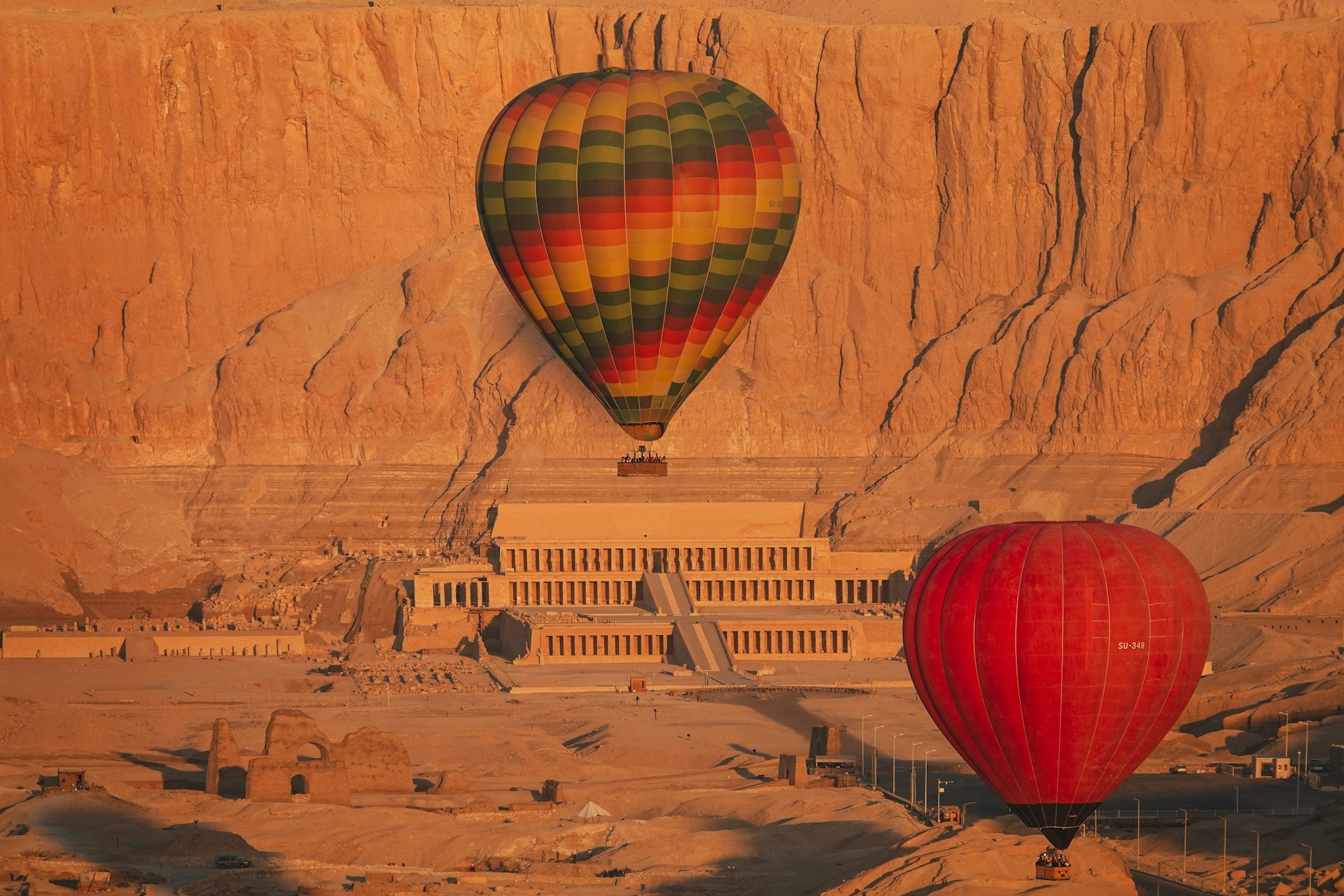 A couple of hot air balloons flying over a desert